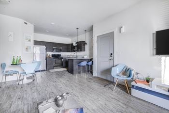 a living room and kitchen with a table and chairs
